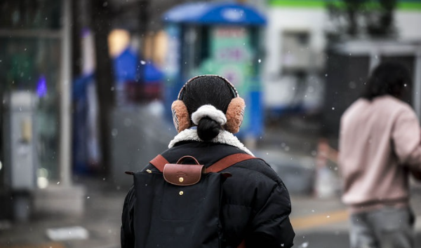 서울 종로구 헌법재판소 인근에서 시민들이 내리는 눈을 맞으며 이동하고 있다.