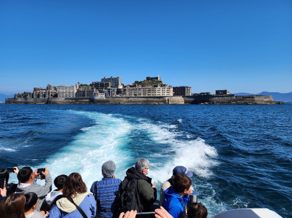 유람선에서 군함도를 바라보는 관광객들