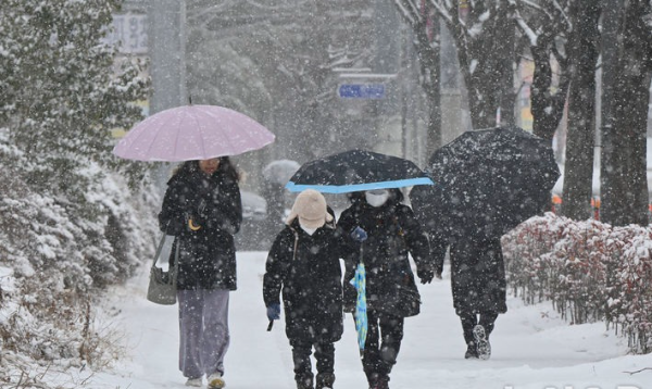 광주·전남 대부분 지역에 대설특보가 내려진 4일 오전 광주 북구 오치동 한 인도에서 시민들이 발길을 재촉하고 있다.
