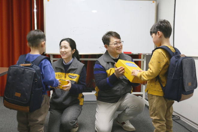 KB국민카드 직원들이 초등학교 입학을 앞둔 아동들에게 책가방을 전달하고 있다. ⓒ KB국민카드