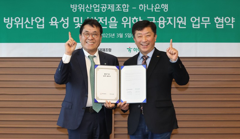하나은행은 5일 방위산업공제조합과 K-방위산업의 육성 및 금융 지원을 위한 업무협약을 체결했다. 이날 협약식에 참석한 김진우 하나은행 중앙영업그룹 부행장(사진 왼쪽)이 김희철 방위산업공제조합 상근부이사장(사진 오른쪽)과 협약서를 들고 기념촬영을 하고 있다.