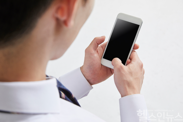 스마트폰을 장시간 사용하며 고개를 숙인 자세가 목 디스크와 거북목 증후군을 유발할 수 있어 바른 자세와 스트레칭이 중요하다. (클립아트코리아)
