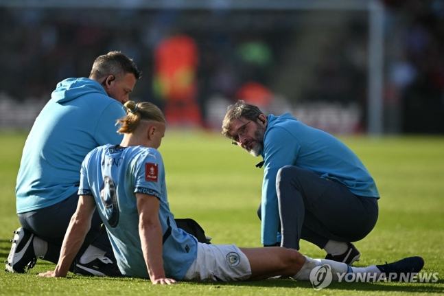 그라운드에 주저앉아 발목 치료를 받는 엘링 홀란