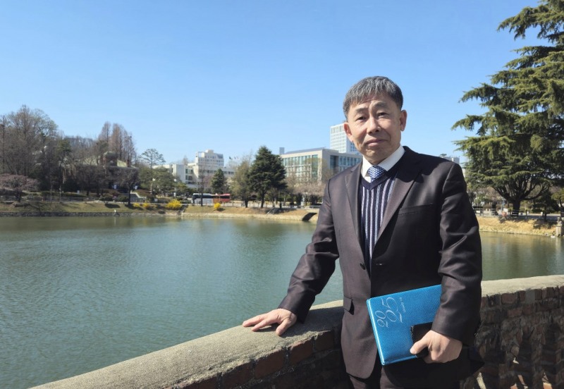 신동만 목사가 양지사에서 제작한 다이어리(일기장)를 손에 들고 건국대학교 일감호에서 본지와 인터뷰하고 있다. 김동현 기자