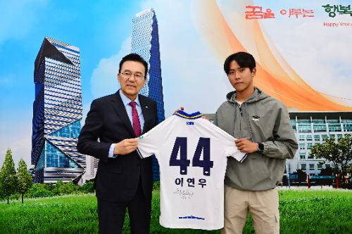 이연우 선수가 친필사인 유니폼을 이재호 구청장께 전달하고 있다.