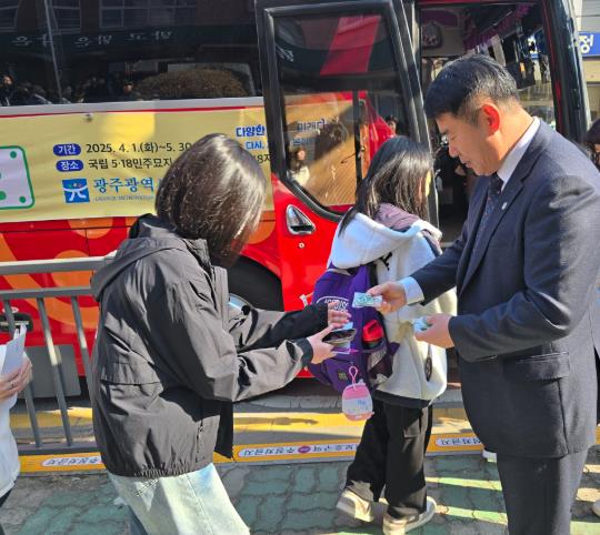 탑승하는 학생들에게 '오월 버스 키링'을 전달하는 이정선 교육감