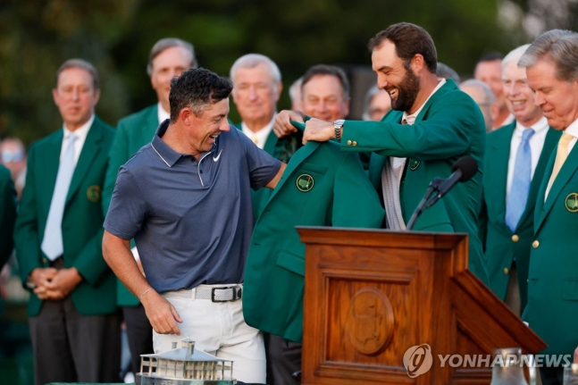 지난해 우승자 스코티 셰플러가 입혀주는 그린 재킷 입는 매킬로이