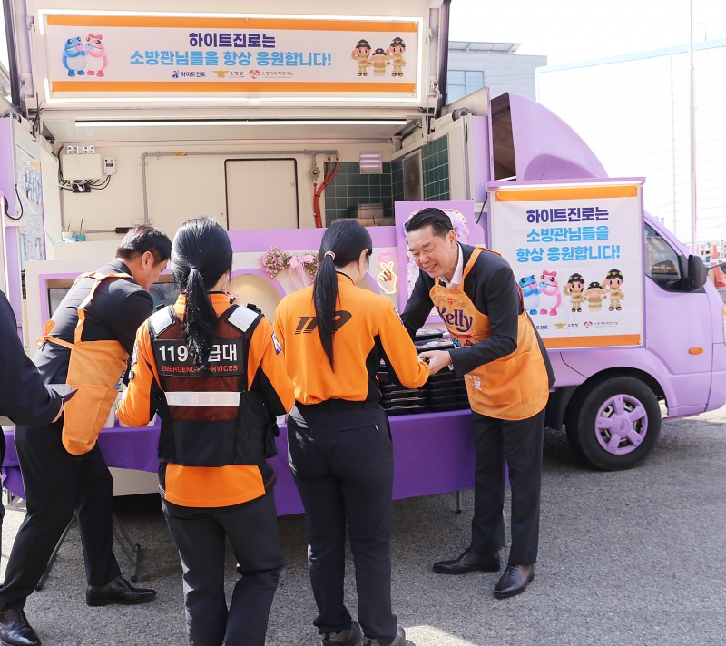 지난 16일 전남 목포소방서에서 김인규 하이트진로 대표(오른쪽)가 소방공무원들에게 간식을 직접 전달하고 있다.