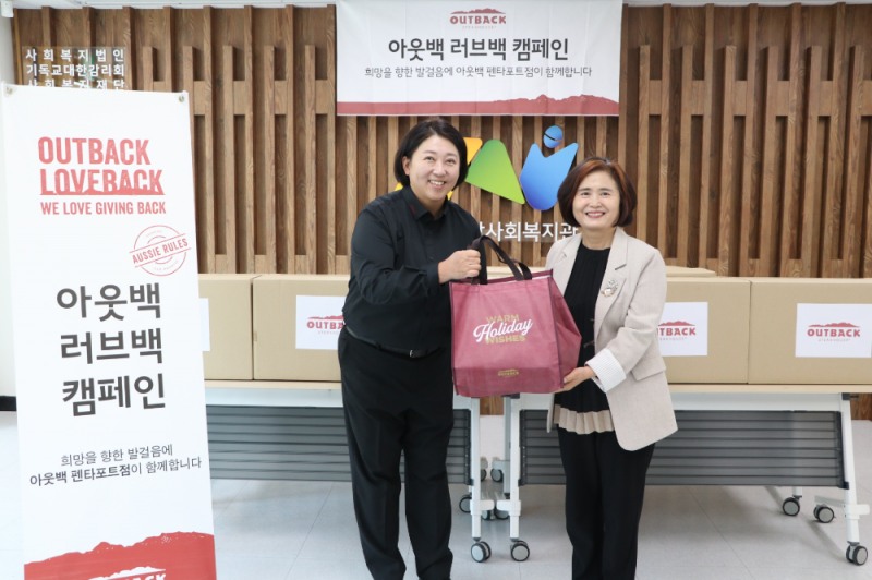 아웃백 천안펜타포트점 박금석 점주가 천안시장애인종합복지관 문명희 관장에게 도시락 세트를 제공하는 모습