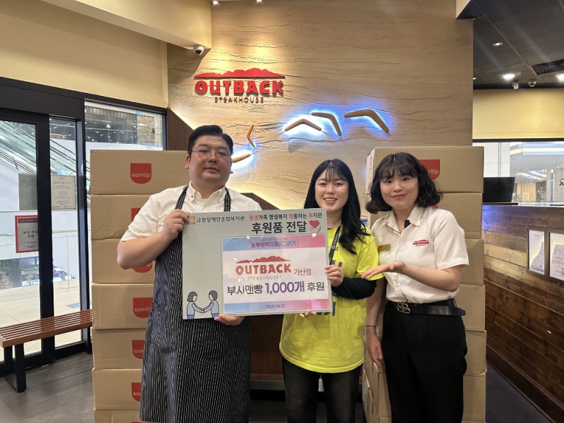 아웃백 서울 가산점 감영준 점주가 금천장애인종합복지관 담당자에게 부시맨 브레드 1,000개를 후원하는 모습