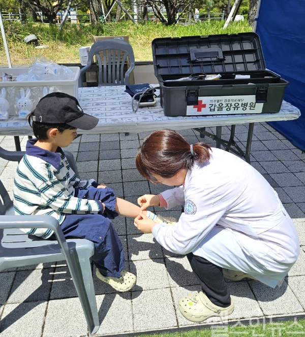갑을장유병원 의료진이 이번 달 4일~5일 김해서부문화센터 야외광장에서 열린 2025 ‘김해 누리아리 어린이 축제’에 참가한 어린이를 치료하고 있다. (갑을장유병원 제공)