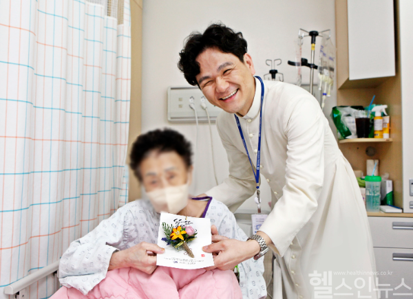 가톨릭대 대전성모병원 원목실 김제동 실장신부가 8일 오전 입원환자에게 카네이션을 전달하고 기념촬영을 하고 있다. (가톨릭대 대전성모병원 제공)
