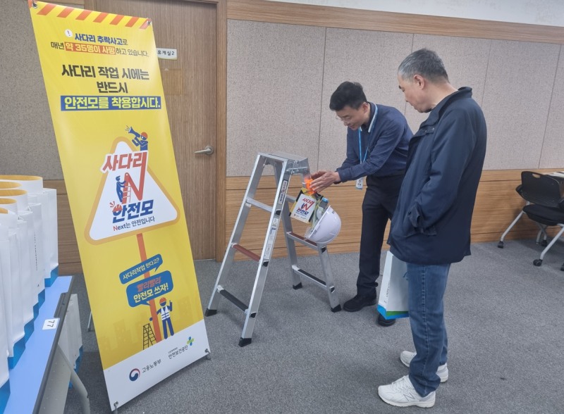 윤현진 안전보건공단 서울남부지사 경영교육부장(왼쪽)이 대한주택관리사협회 소속 공동주택관리소장에게 안전모 걸를 설명하고 있다./안전보건공단 서울남부지사