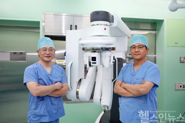 구도훈 인제대학교 해운대백병원 갑상선‧내분비외과 교수(오른쪽)와 배동식 교수(왼쪽)가 다빈치 SP 로봇수술기 앞에서 기념촬영을 하고 있다. (해운대백병원 제공)