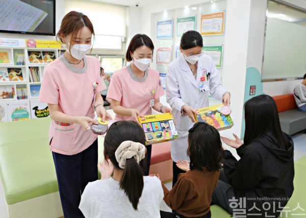 한림대성심병원 직원들이 5월 가정의 달을 맞아 소아청소년과 외래 대기공간에서 어린이 환자들에게 선물을 전달하고 있다. (한림대성심병원 제공)