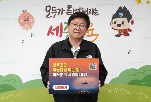 최교진 세종시교육감이 14일 ‘청주공항 민간전용활주로 건설, 100만 서명운동 동참’ 피켓을 들고 활주로 확충의 당위성을 알리고 있다.