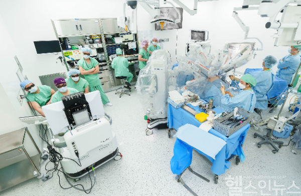 지난 8일, 정창욱 서울대병원 비뇨의학과 교수팀이 전립선 절제술에 휴고를 활용하는 모 습. 집도의(사진 좌측, 보라색 두건 착용) 및 다른 의료진이 개방형 콘솔에 탑재된 3D TV로 수술 장면을 함께 바라보고 있다. (메드트로닉 제공)