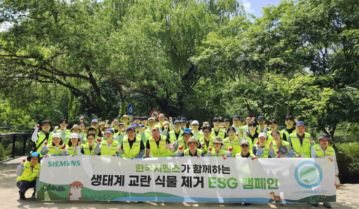 한국지멘스 임직원들이 22일 서울 여의도 샛강 생태공원 일대에서 ‘생태계 교란 식물 제거 ESG 캠페인’을 진행한 뒤 기념사진을 촬영하고 있다.