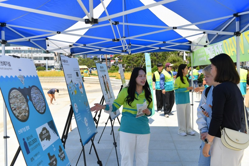 부산 광안리해수욕장에서 25일 ASEZ WAO가 개최한 거리캠페인에서 시민들이 패널 전시를 통해 플라스틱 오염의 심각성을 확인하고 있다.