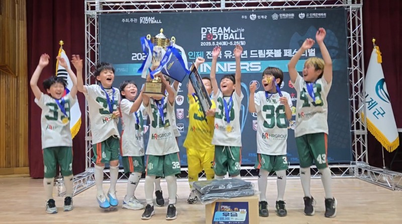 지난 24일부터 25일까지 열린 ‘2025 하늘내린 인제 전국 유소년 드림풋볼 페스티벌’ 시상식 무대에서, HR U-12 4학년부가 우승을 차지한 뒤 주장 최강건 선수가 우승 트로피를 힘차게 들어 올리며 동료들과 함께 환호하고 있다./사진=HR그룹 미디어팀 제공