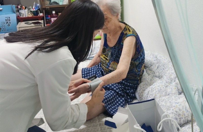 보건 전문가가 지역주민 혈압을 측정 중인 모습