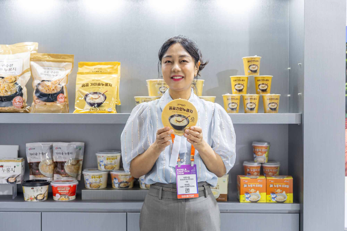 2025 디지털 유통·물류대전에 참가한 대한식품 한윤경 대표가 자사 제품을 들고 포즈를 취하고 있다.