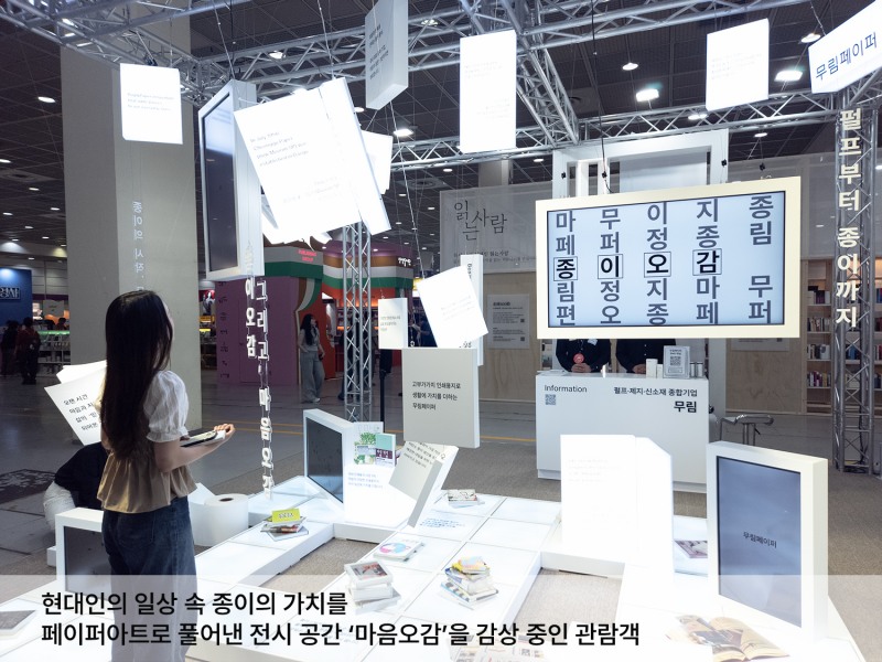 대형 종이책과 디지털 디스플레이가 어우러진 '마음오감' 공간. 천장에 펼쳐진 종이책 설치물과 일상 속 종이의 가치를 담은 문장들을 감상하며, 종이가 함께하는 현대 사회의 풍경을 페이퍼 아트로 체험할 수 있다. / 사진제공=무림