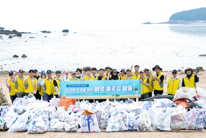 동서식품이 지난 19일 인천 무의도 해안가에서 플로깅 직원 봉사활동을 진행했다. 봉사활동에 참여한 동서식품 직원들이 기념촬영을 하고 있다.