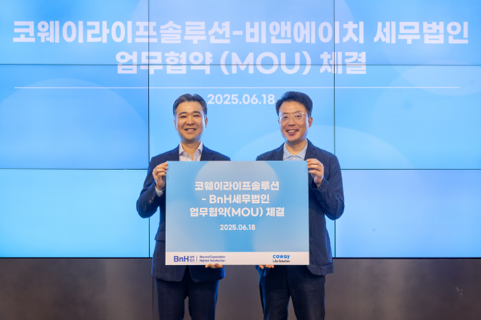 지난 18일 서울 구로구 지타워 코웨이라이프솔루션 본사에서 열린 협약식에서 김명곤 코웨이라이프솔루션 대표이사(오른쪽)와 이명수 BnH세무법인 부대표(왼쪽)가 기념 촬영을 하고 있다.