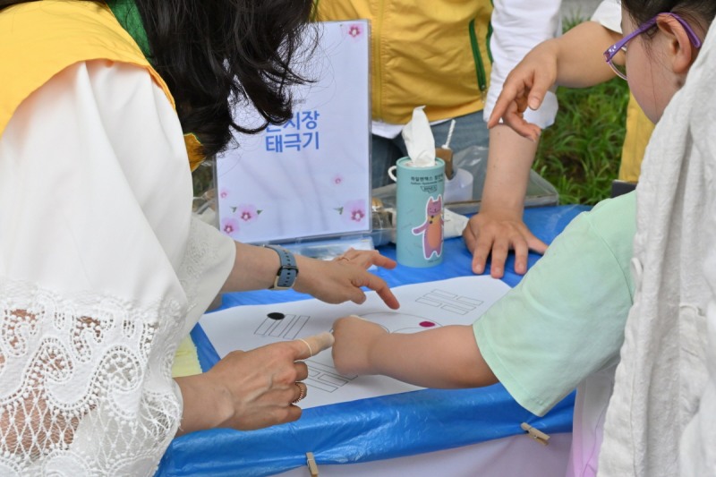 지난 21일 보라매공원 인근에서 열린 '나라 사랑 평화 나눔 캠페인'이 열린 가운데 한 아이가 손도장으로 태극기를 만들고 있다.(사진 제공: 신천지자원봉사단 동작지부)