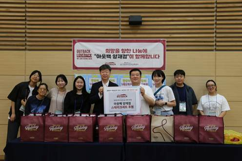 21일, 아웃백 양재점 지준형 점주(좌측에서 여섯 번째)와 서초구립 한우리정보문화센터 이재용 관장(좌측에서 다섯 번째)을 비롯한 관계자들이 '러브백 캠페인' 기념사진을 촬영하고 있다.