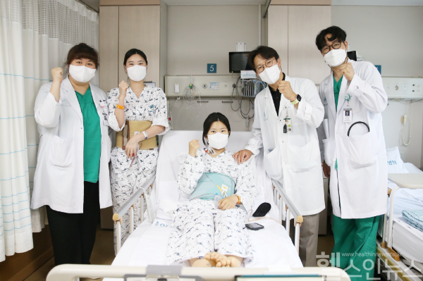 다낭성 신증후군으로 만성 신부전을 앓던 이가영 씨(가운데)가 로봇 신장이식 후 순조롭게 회복하며 20일(금) 의료진과 기념사진을 찍고 있다. 왼쪽에서 두 번째가 공여자인 언니 이 모 씨, 네 번째가 수술을 집도한 신성 서울아산병원 신·췌장이식외과 교수. (서울아산병원 제공)