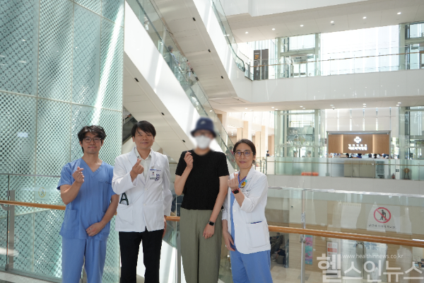 수술 후 건강을 되찾은 환자(오른쪽 두 번째)가 정원범 인제대학교 해운대백병원 교수, 김일환 교수, 정보현 교수(왼쪽부터)와 함께 기념 촬영을 하고 있다. (해운대백병원 제공)