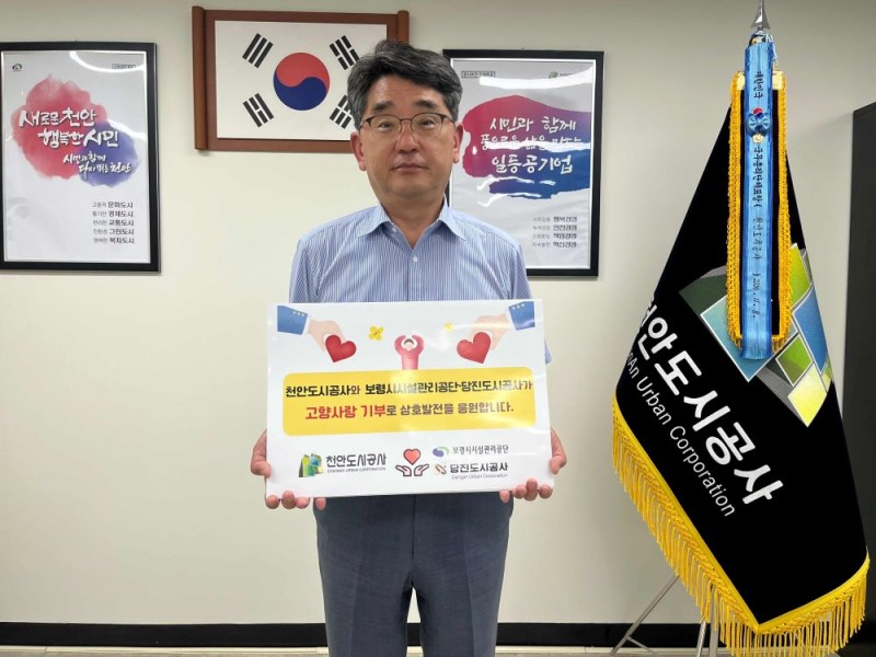 천안도시공사 신광호 사장이 고향사랑기부제 교차기부증서를 들고 있다.