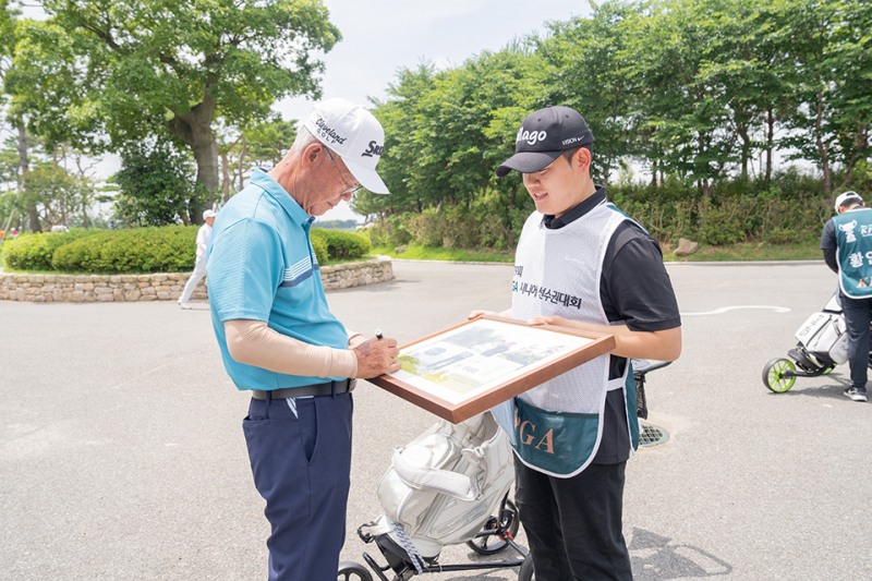 박남신(왼쪽)이 기념 액자에 사인하고 있다. /KPGA