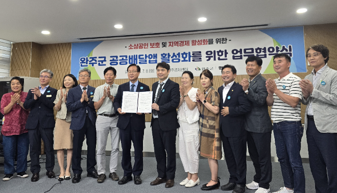 완주군 공공배달앱 업무 협약서를 들고 있는 유희태 완주 군수(좌측)과 김주형 먹깨비 대표(우측)