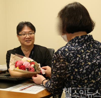 50대 말기 신부전 환자가 고도 감작으로 재이식이 어려운 힘든 상황을 이겨내고 두 번째 신장이식 수술로 건강을 되찾고, 정병하 서울성모병원 신장내과 교수에게 뜨개질로 만든 카네이션 꽃다발을 전하고 있다. (서울성모병원 제공)