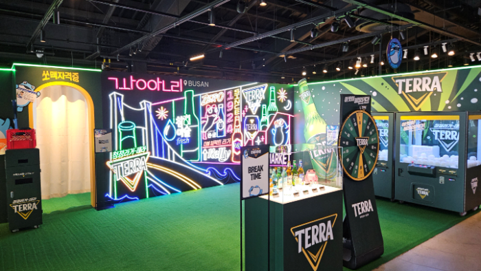 하이트진로는 부산 밀락더마켓 2층에 ‘테라’ 브랜드 체험 공간 ‘두껍더마켓’을 마련해 네온 포토존, 쏘맥자격증 체험존, 경품 이벤트 등을 9월 30일까지 운영한다.