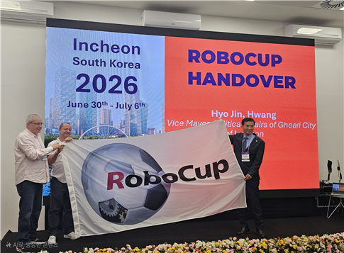 황효진 인천시 글로벌도시정무 부시장이 로보컵(RoboCup) 2025' 폐막식에서 차기 개최지로서 대회 상징인 대회기를 인수하고 있다.