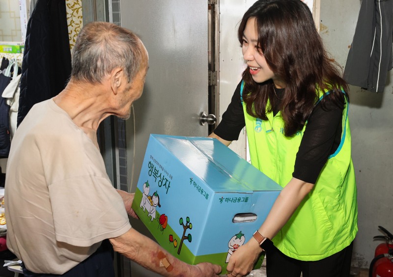 하나금융그룹은 지난 21일 기록적인 폭염으로 어려움을 겪고 있는 지역사회 취약계층을 위해 여름철 필수품이 담긴 ‘시원한 여름나기 행복상자’ 1111개를 전달했다고 밝혔다. 이날 행사에 참석한 하나금융그룹 직원이 창신동 인근 쪽방촌에 찾아가 독거 어르신에게 행복상자를 전달하고 있다./하나금융그룹