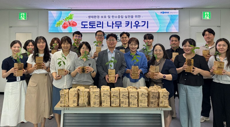 코레일네트웍스 대표이사 전찬호(앞줄 중앙) 및 임직원들이 100일 동안 직접 기른 도토리 묘목을 들고 기념촬영을 진행하고 있다.