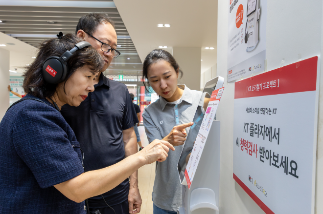 KT플라자에 방문한 고객이 KT 직원으로부터 AI 청력검사 키오스크의 사용법에 대한 설명을 듣고 있다.