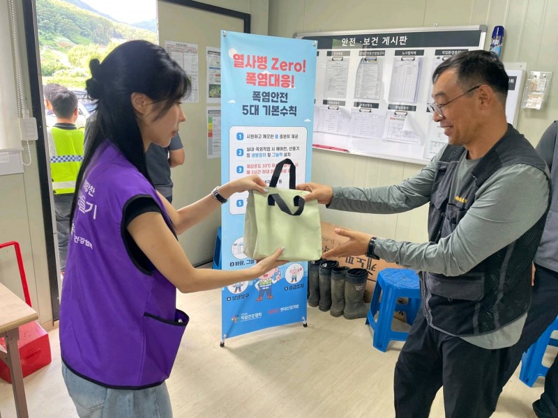 한국직업건강간호협회 직원이 현대산업개발 김해 토목공사 현장 근로자에게 폭염대응키트를 전달하고 있다./한국직업건강간호협회