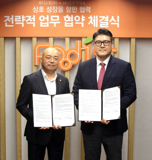 하동열 푸디스트 상품본부장(사진 왼쪽)과 손동일 천호엔케어 대표이사가 '케어푸드' 브랜드 공동개발 협약식 후 기념촬영을 하고 있다.