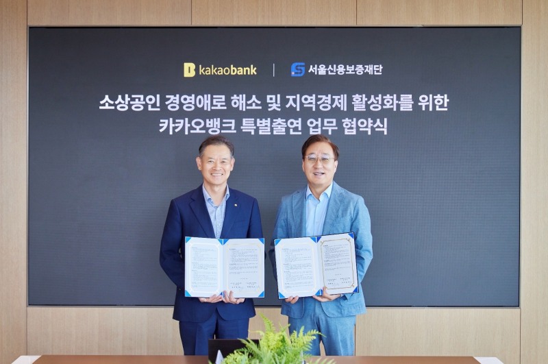 카카오뱅크 윤호영 대표이사(오른쪽)와 최항도 서울신용보증재단 이사장(왼쪽)이 지난 25일 경기도 성남시 카카오뱅크 판교오피스에서 진행된 '카카오뱅크 특별출연 업무 협약식'에 참석해 기념 촬영을 하고 있다./카카오뱅크