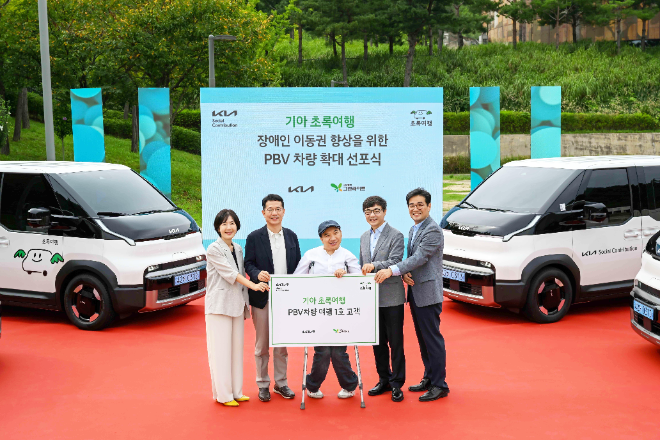 기아 지속가능경영실장 이덕현 상무(왼쪽 두번째), 사단법인 그린라이트 이재강 회장(왼쪽 네번째) 등 주요 관계자들이 PV5 여행 1호 고객과 기념 촬영을 하고 있는 모습