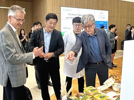 풀무원기술원 김태석 원장(맨 오른쪽)이 기술원 1층 입구에 전시된 두유면, 두부면 등 풀무원의 차별화된 지속가능 혁신제품들을 CIA 미힐 바커 총장(맨 왼쪽)에게 소개하고 있다.