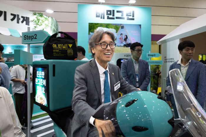 환경부 금한승 차관이 배달의민족 부스에 방문해 배달용 전기 이륜차를 시승하고 있다.