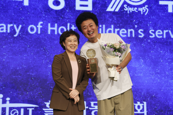 감사패를 수상한 윤택 홍보대사가 신미숙 홀트아동복지회장과 기념촬영을 하고 있다.