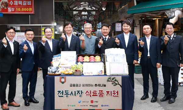 이호성 하나은행장(왼쪽에서 세 번째), 이찬진 금융감독원장(왼쪽에서 네 번째), 심기표 목사랑시장 상인회장(왼쪽에서 다섯 번째), 한세종 구세군 서기장관(왼쪽에서 여섯 번째)이 전통 시장에서 직접 구입한 물품들을 진열하고 기념 촬영을 하고 있다. ⓒ하나은행